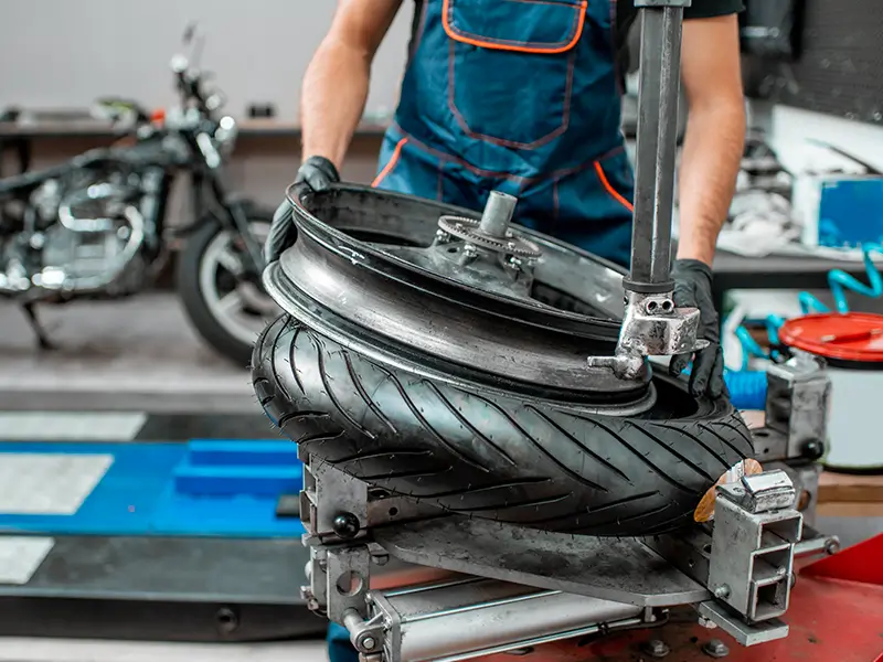 Montage d’un pneu moto en atelier chez Bomerée-Pneus à Montigny-le-Tilleul.