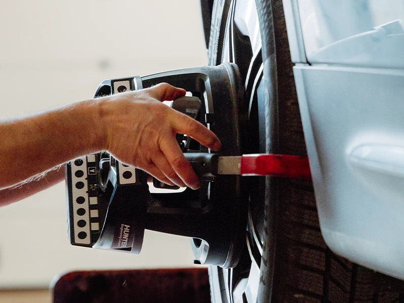 Réglage d’un capteur de géométrie sur une roue de voiture chez Bomerée-Pneus.